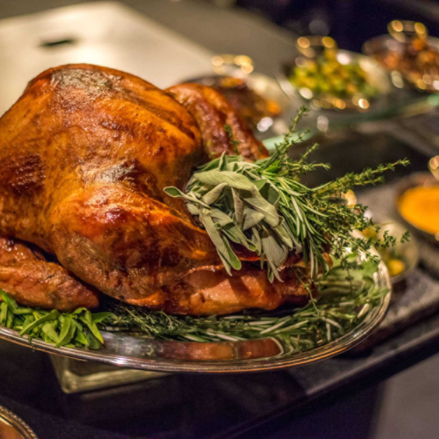 Roast turkey with fresh herbs on silver platter