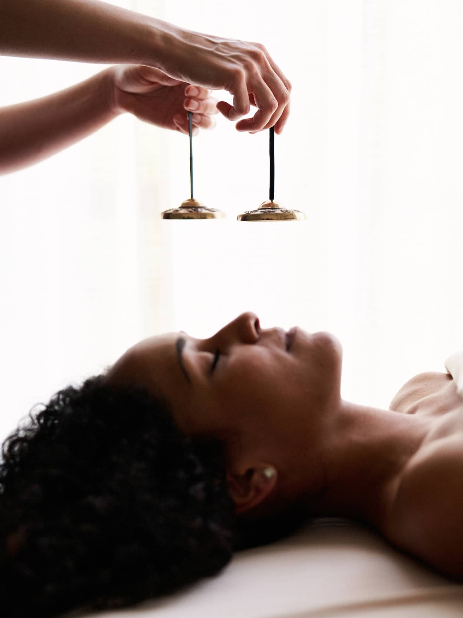 A woman experiencing vibrational sound therapy.