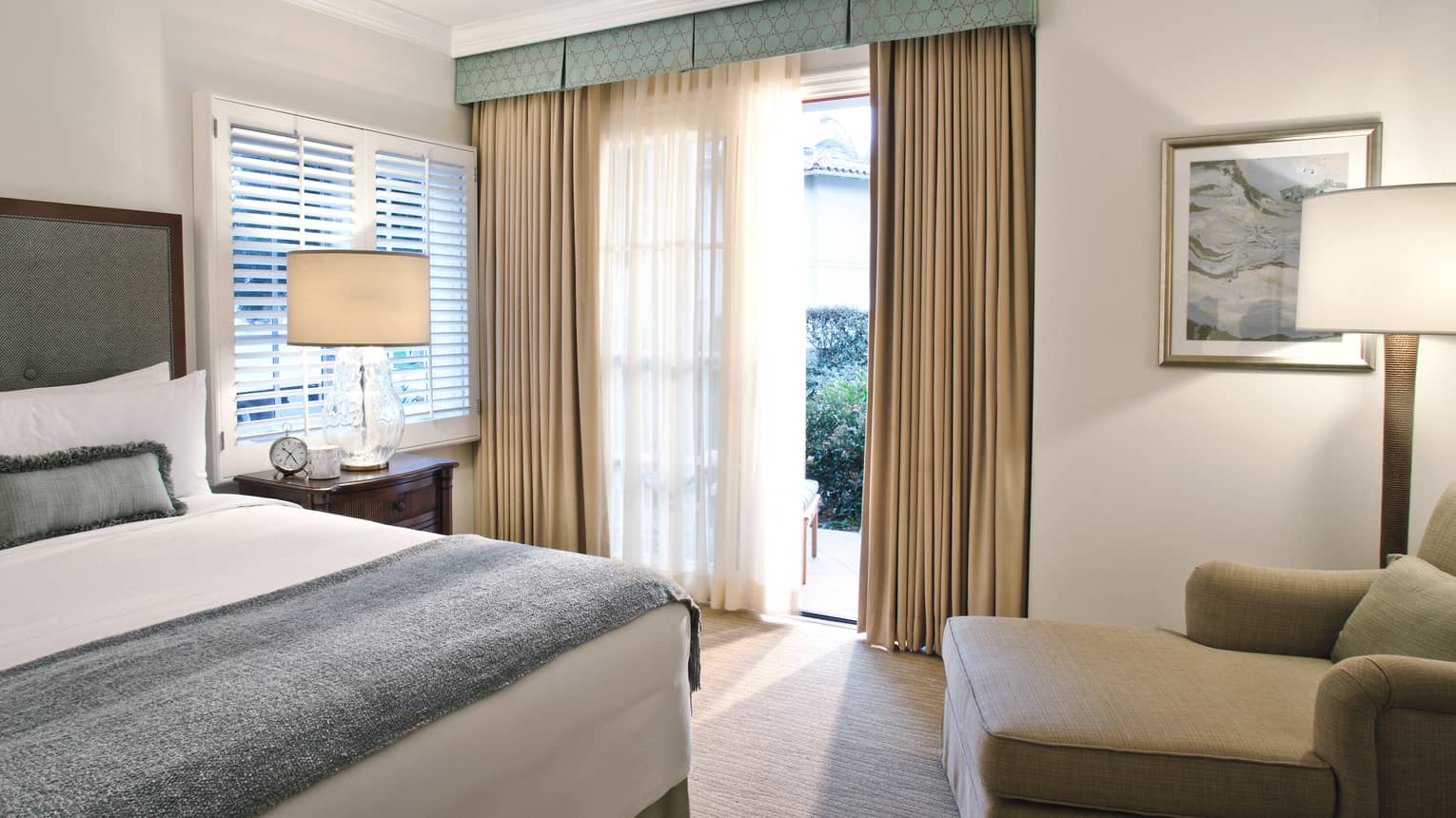 Guest room with queen bed, blue & white linens, chaise, floor-to-ceiling windows 