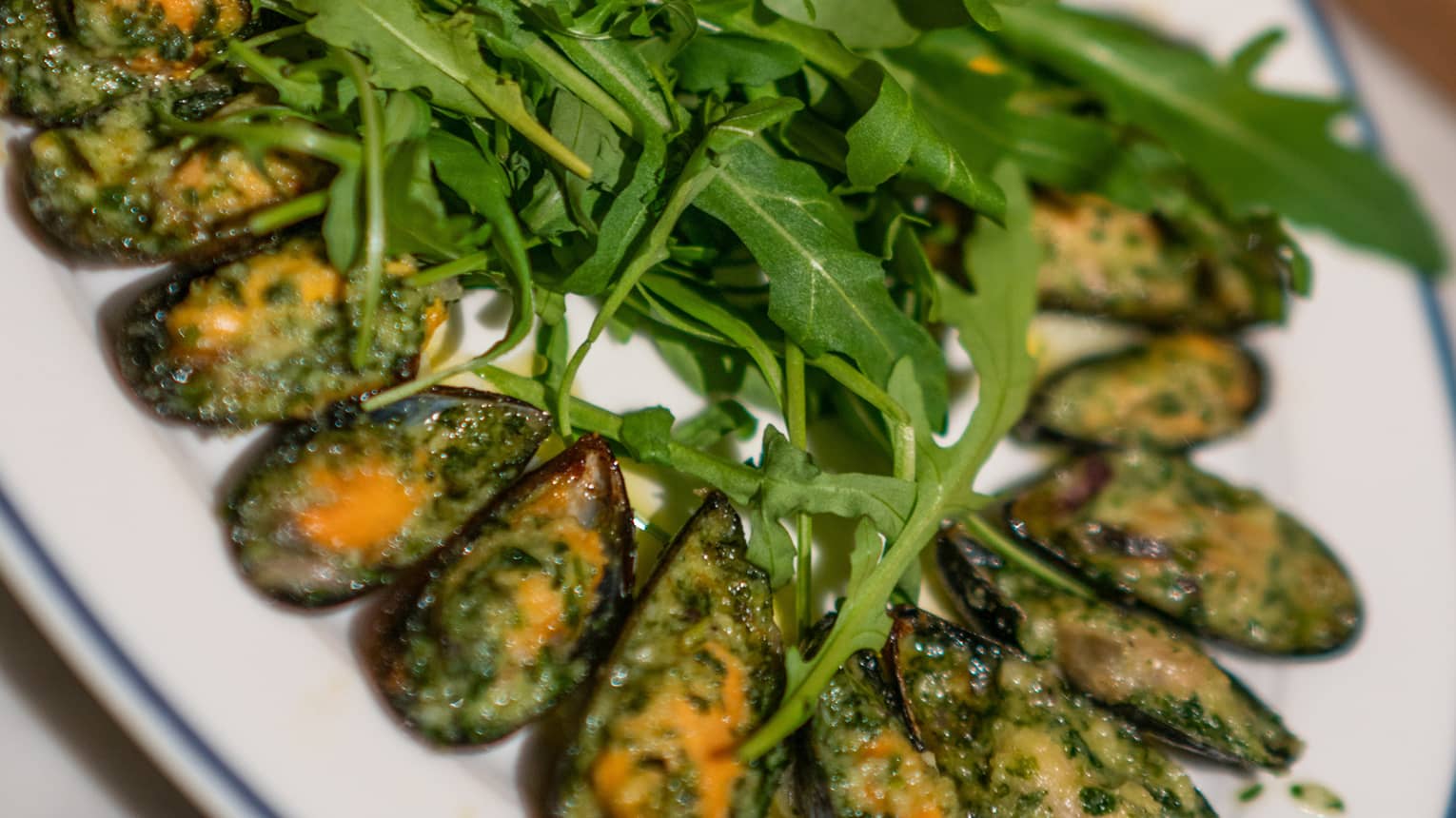 Mussels stuffed with herbs, onion and nuts topped with greens.