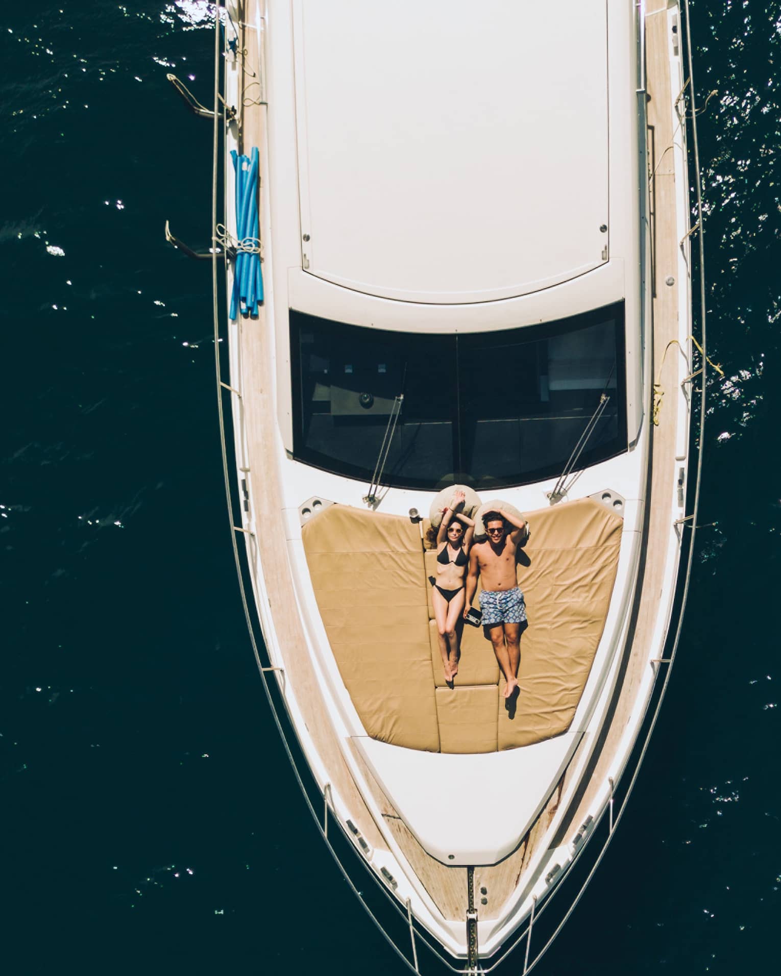 Aerial view of couple relaxing on the front of a large boat
