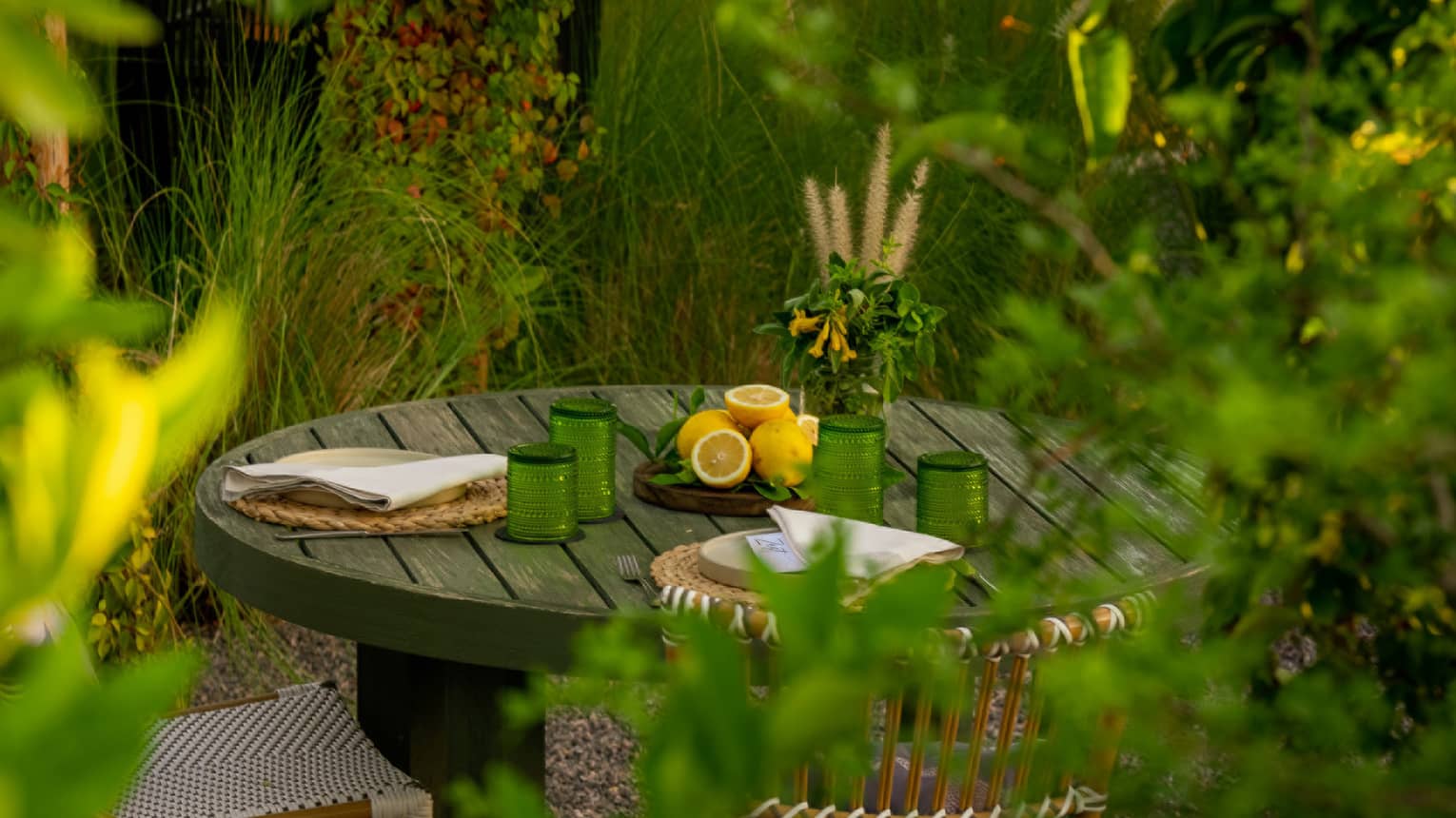 A round wooden table for two tucked in an intimate garden setting