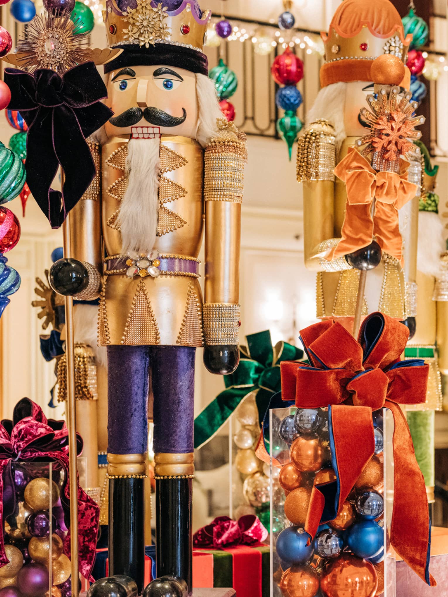 Hotel lobby decorated for the holidays with large gold nutcracker statues and colourful ornaments hangins from the ceiling