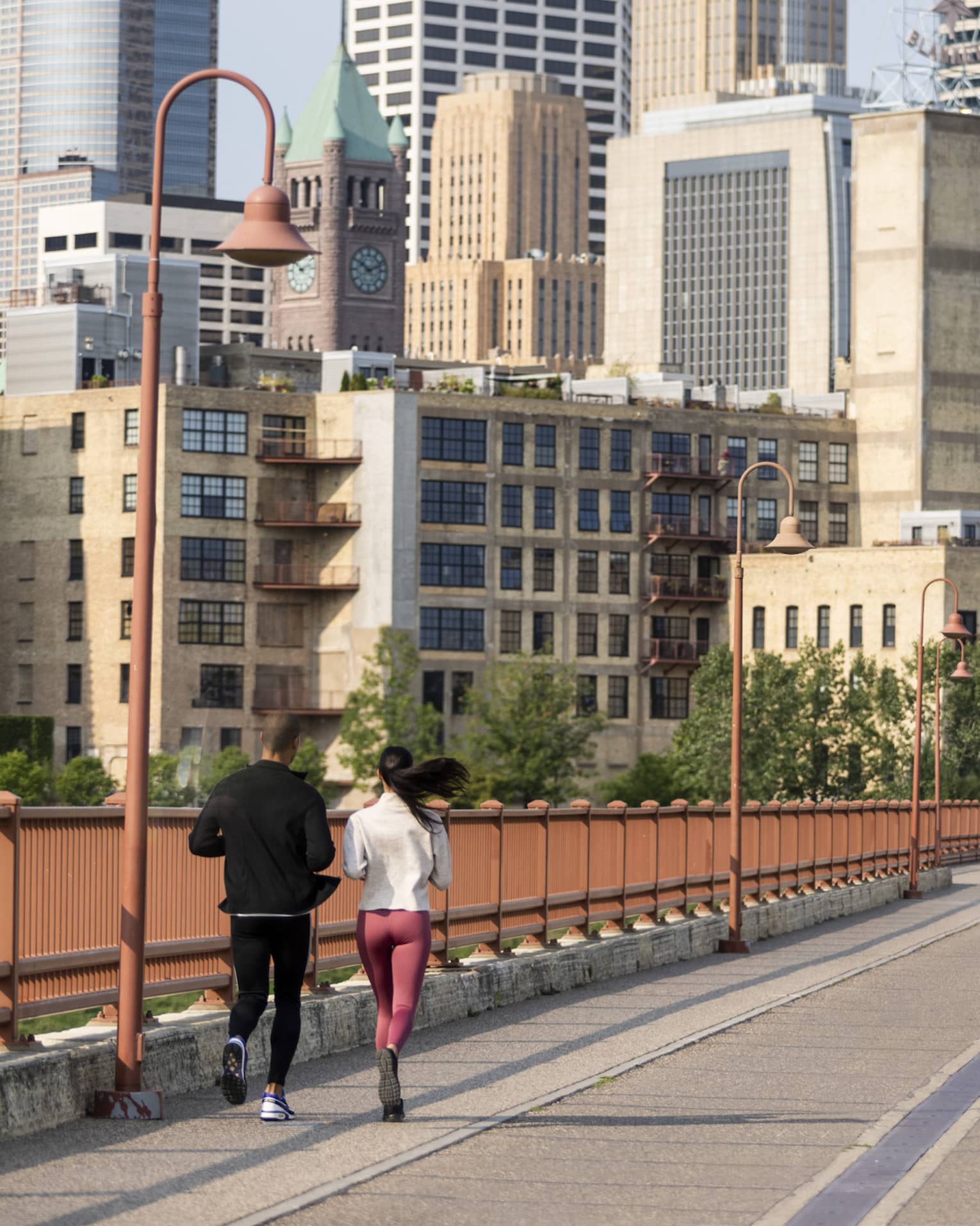 Minnesota city view from bridge, where two people run