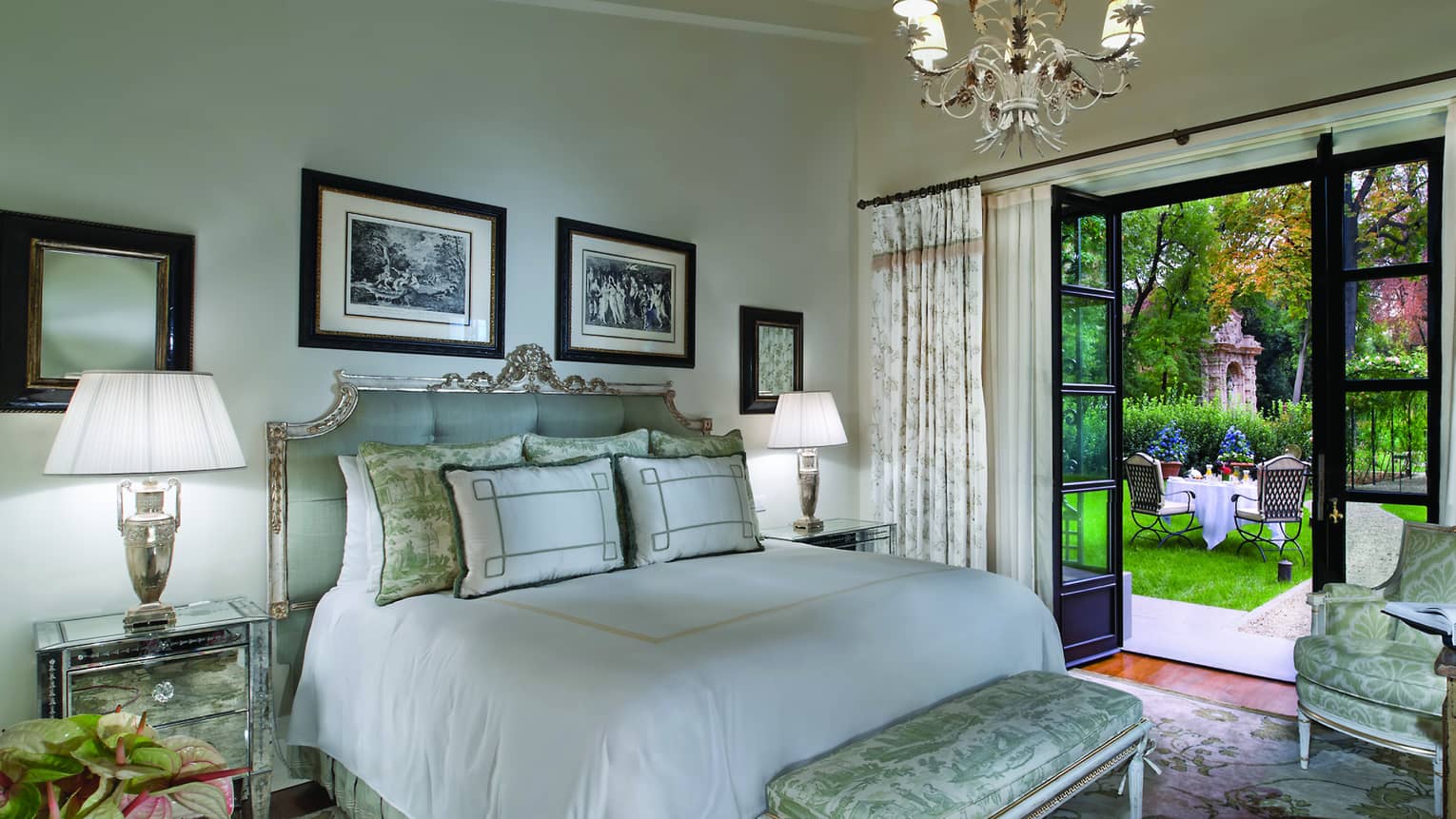 Garden Suite bed with tufted blue headboard, silk bench, open doors to garden patio