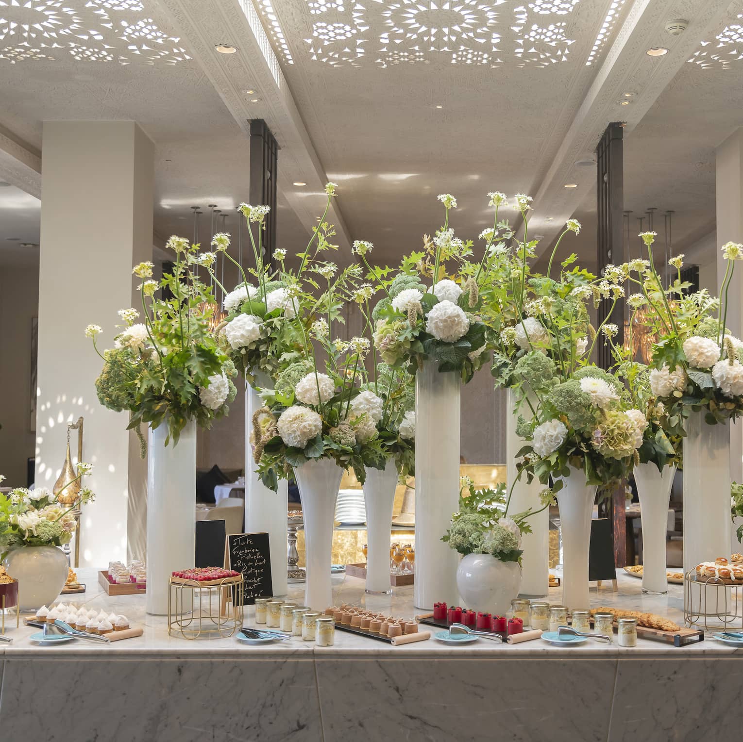 Elaborate buffet at hotel, with large floral arrangements on a table