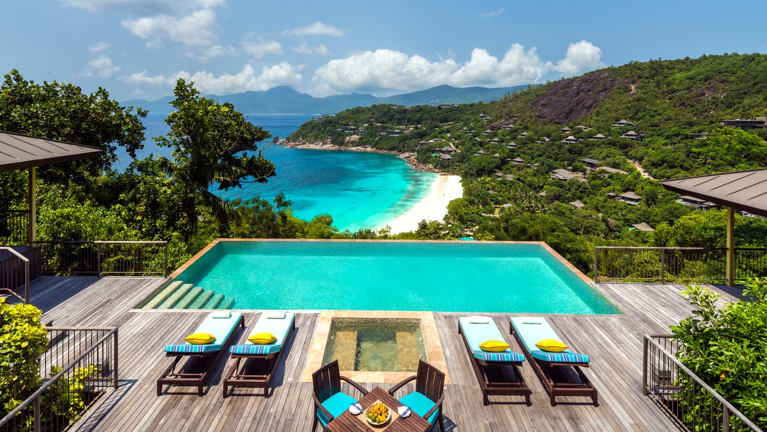 Two-Bedroom Hilltop Ocean-View Suite patio, four lounge chairs on deck by pool, hot tub, overlooking mountains, ocean