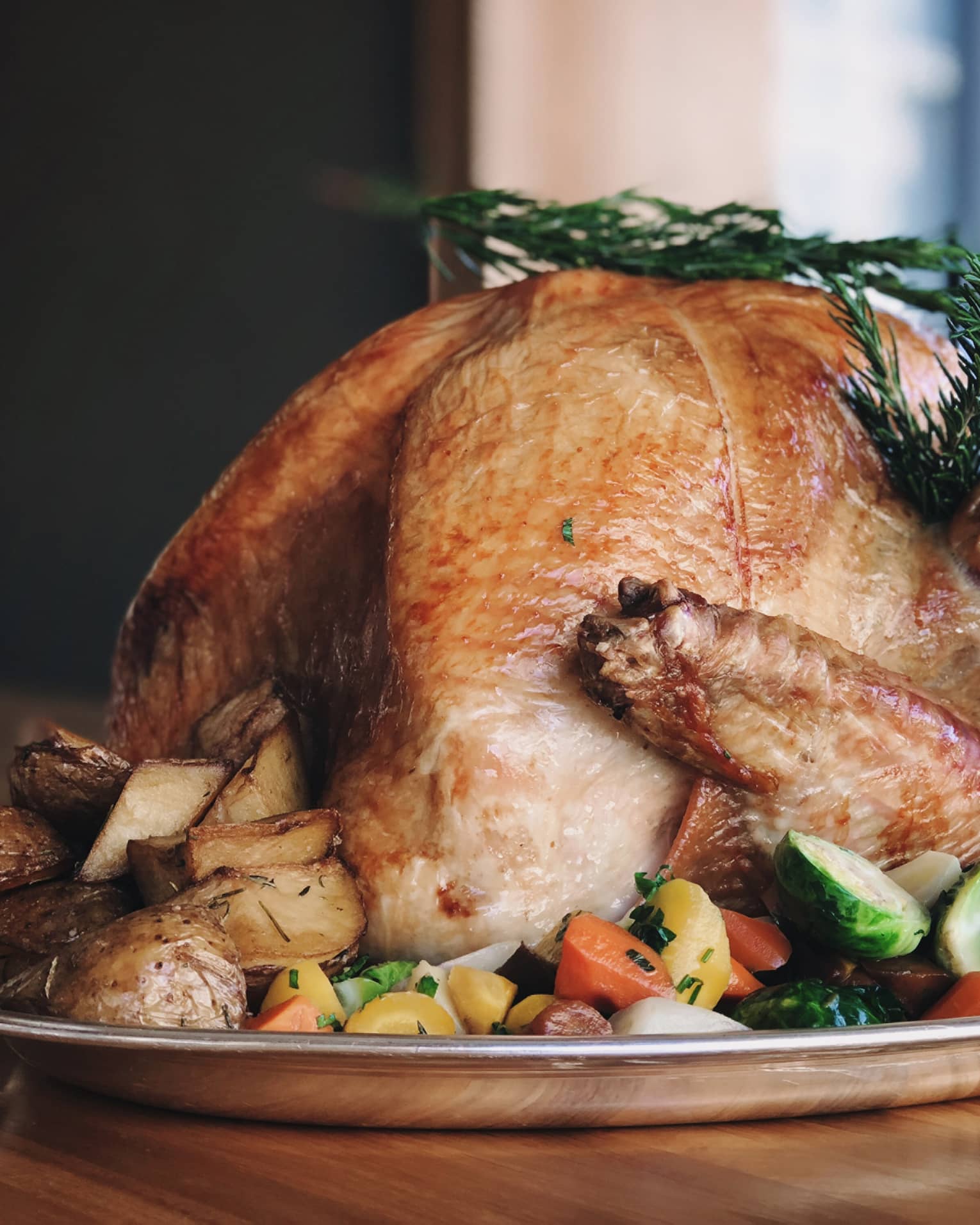 ,A cooked turkey in a large metal tray.