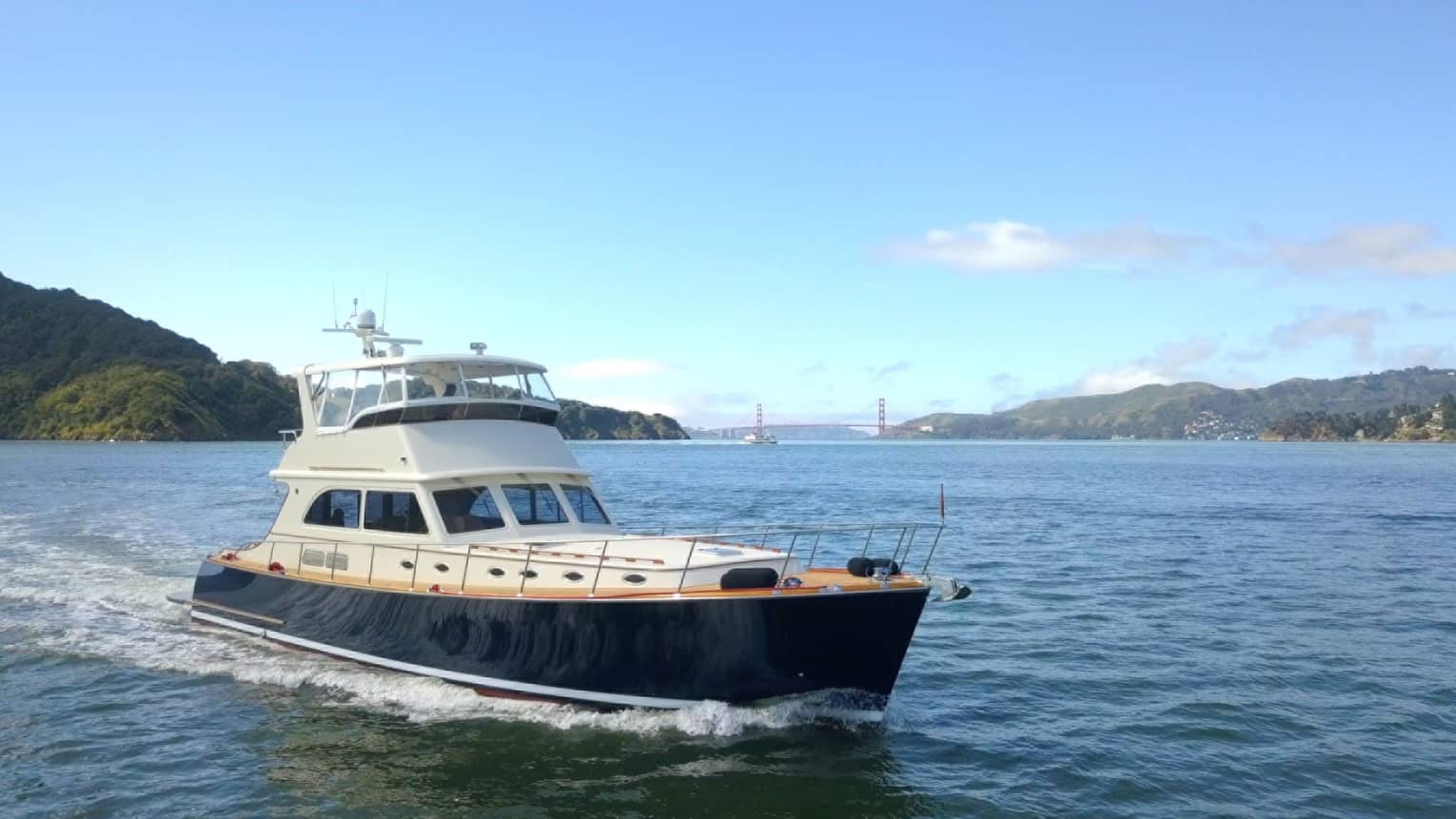 Small yacht sails across bay on sunny day