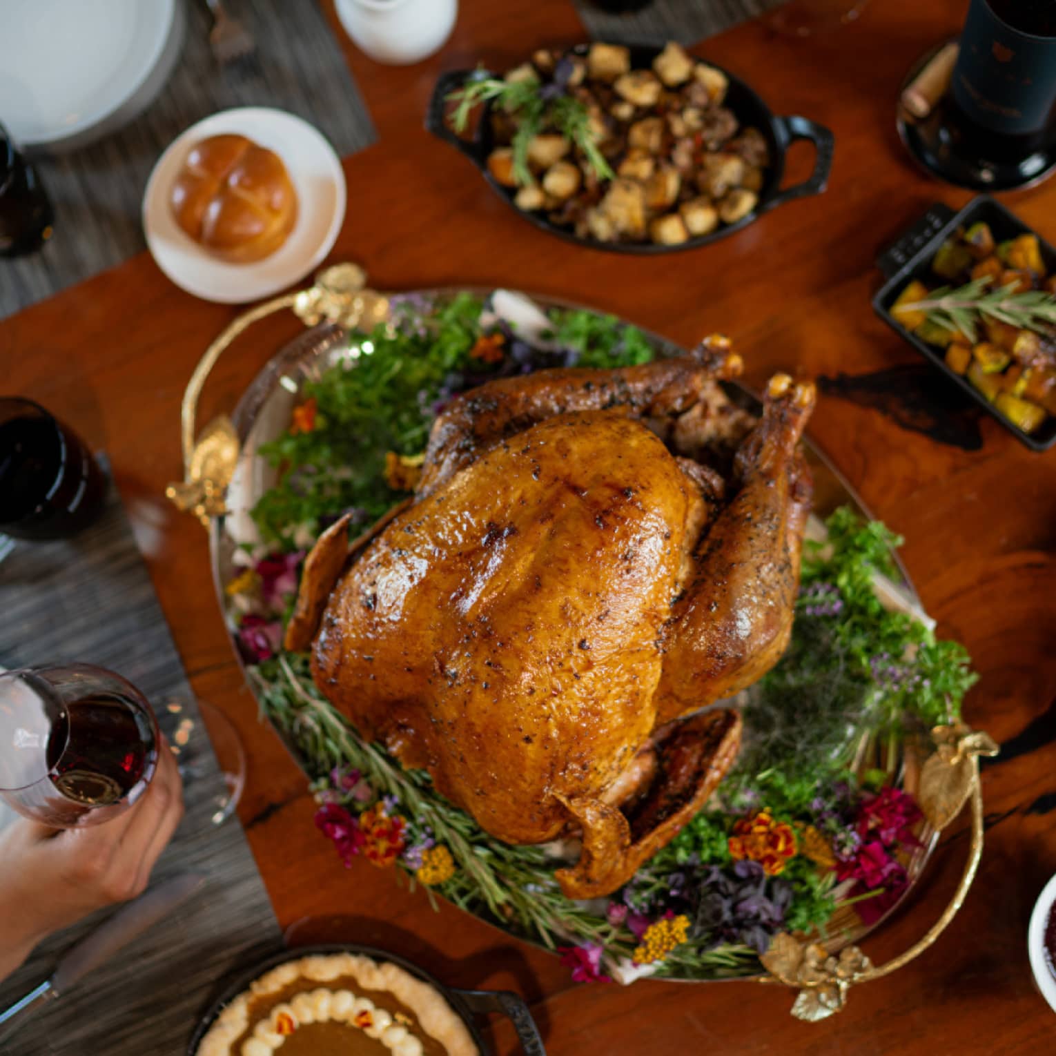 A cooked turkey surrounded by Thanksgiving dishes.