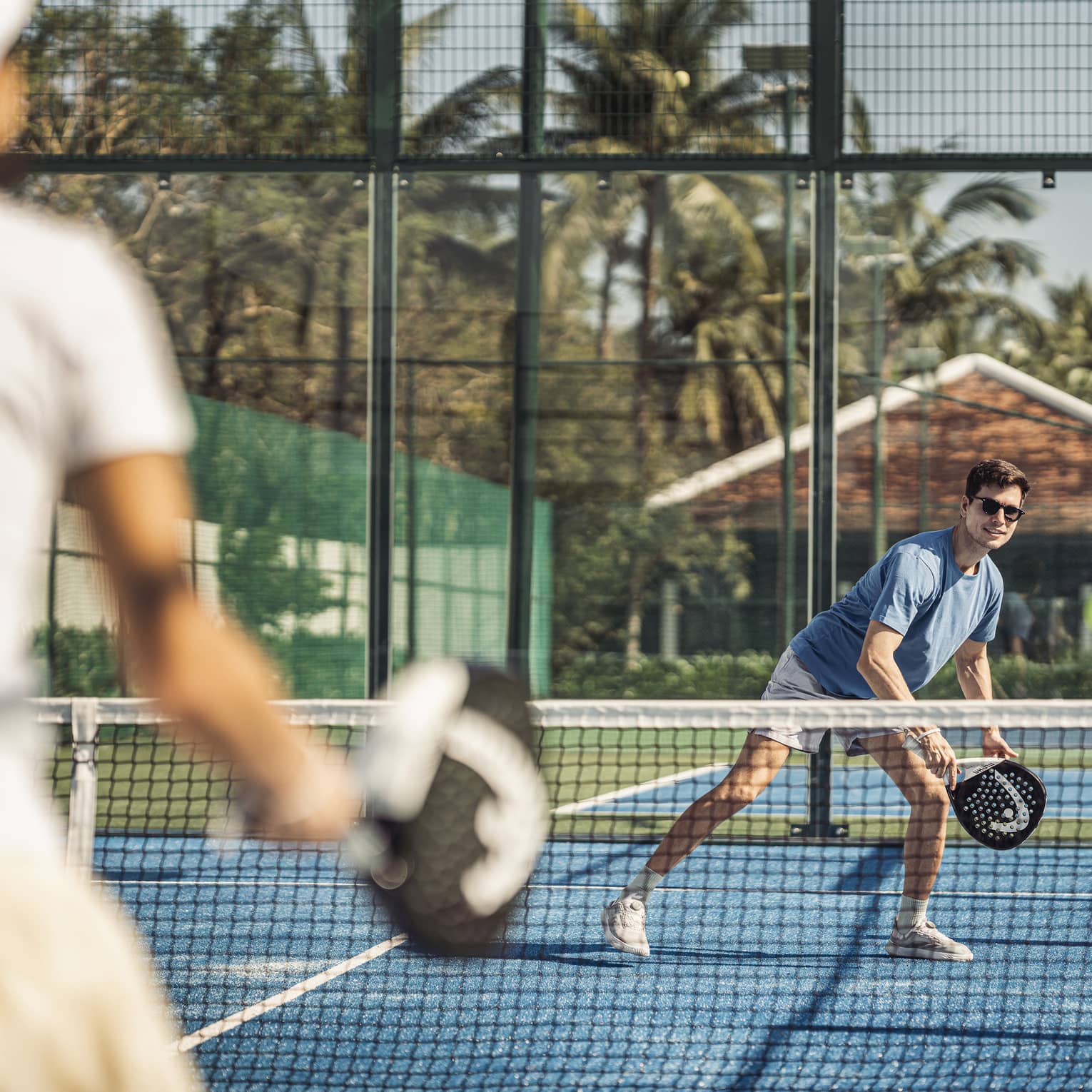 Couple plays paddleball on artificial turf court