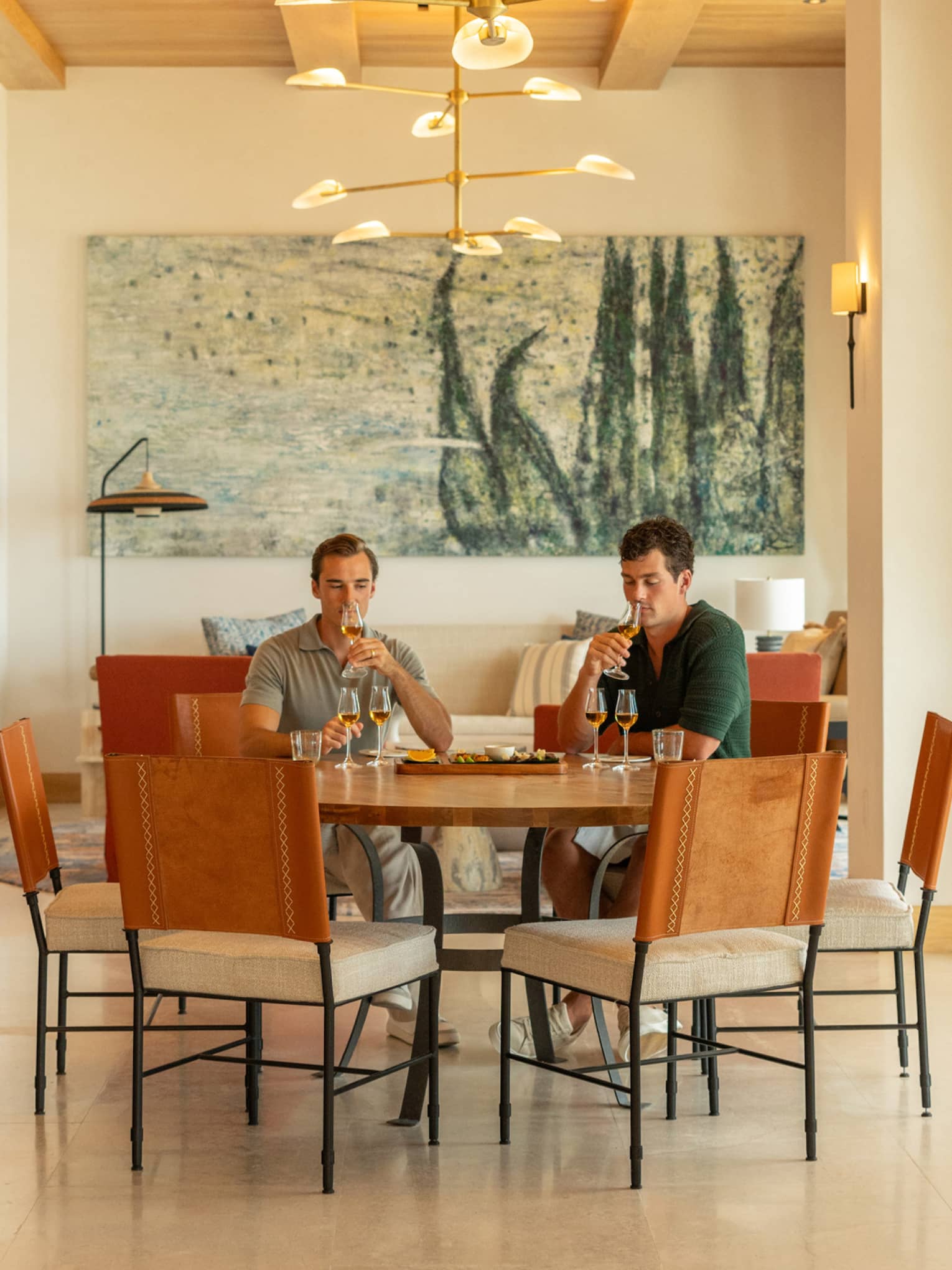 Two people sit at round table in dining room, tasting agave