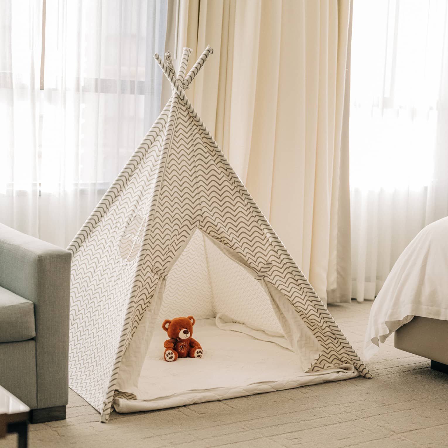 A kids tent with a stuffed animal in a guest room