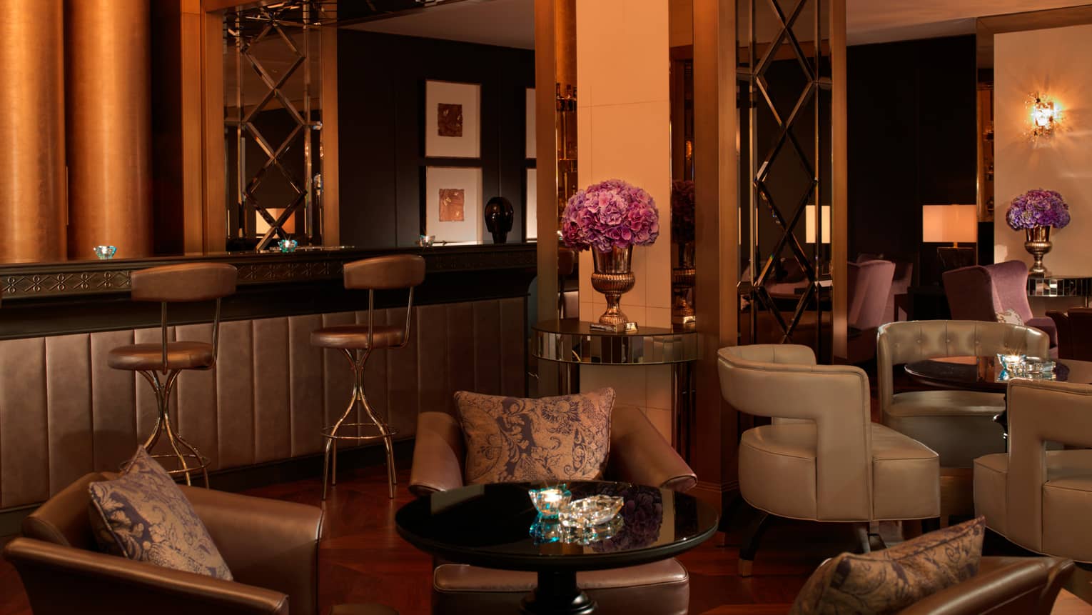 Bentleys bar, brown leather armchairs around cocktail tables, vases with purple flowers