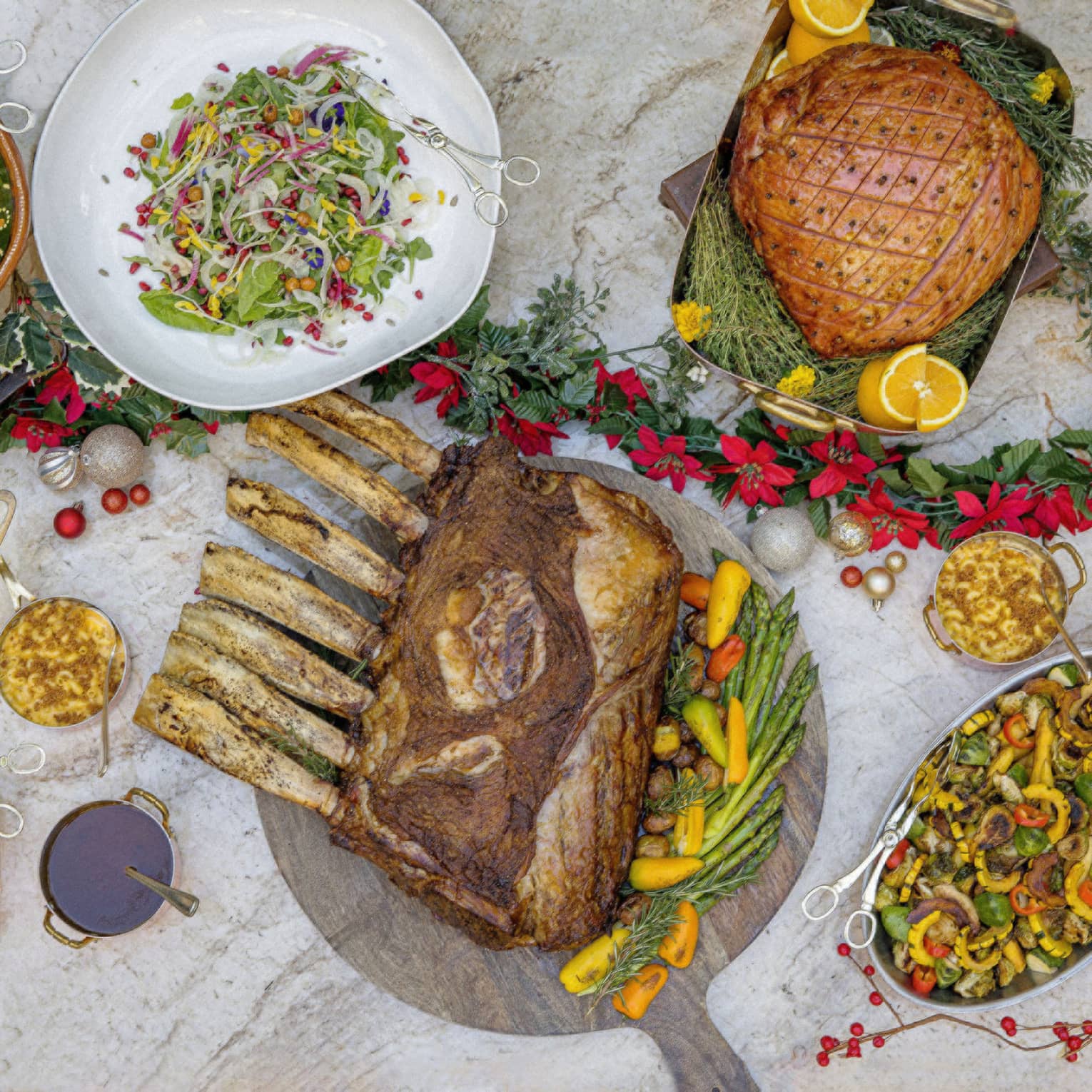A variety of foods including ham and salad on a large table.