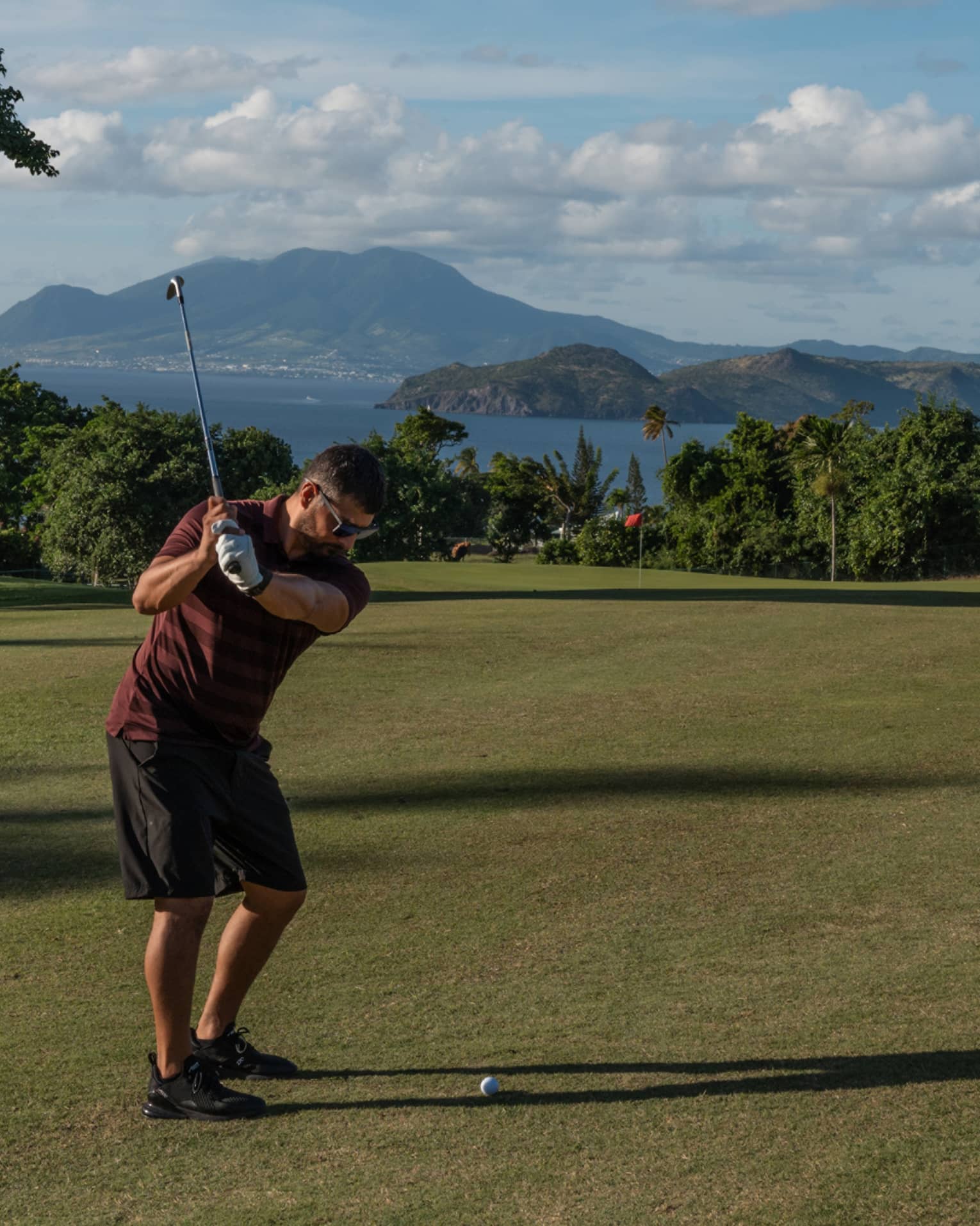 A person swinging a golf club on a golf course
