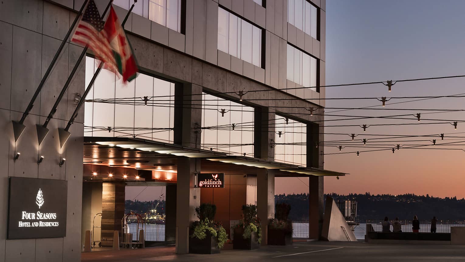 Four Seasons hotel exterior, front entrance with the Seattle Great Wheel in background at sunset