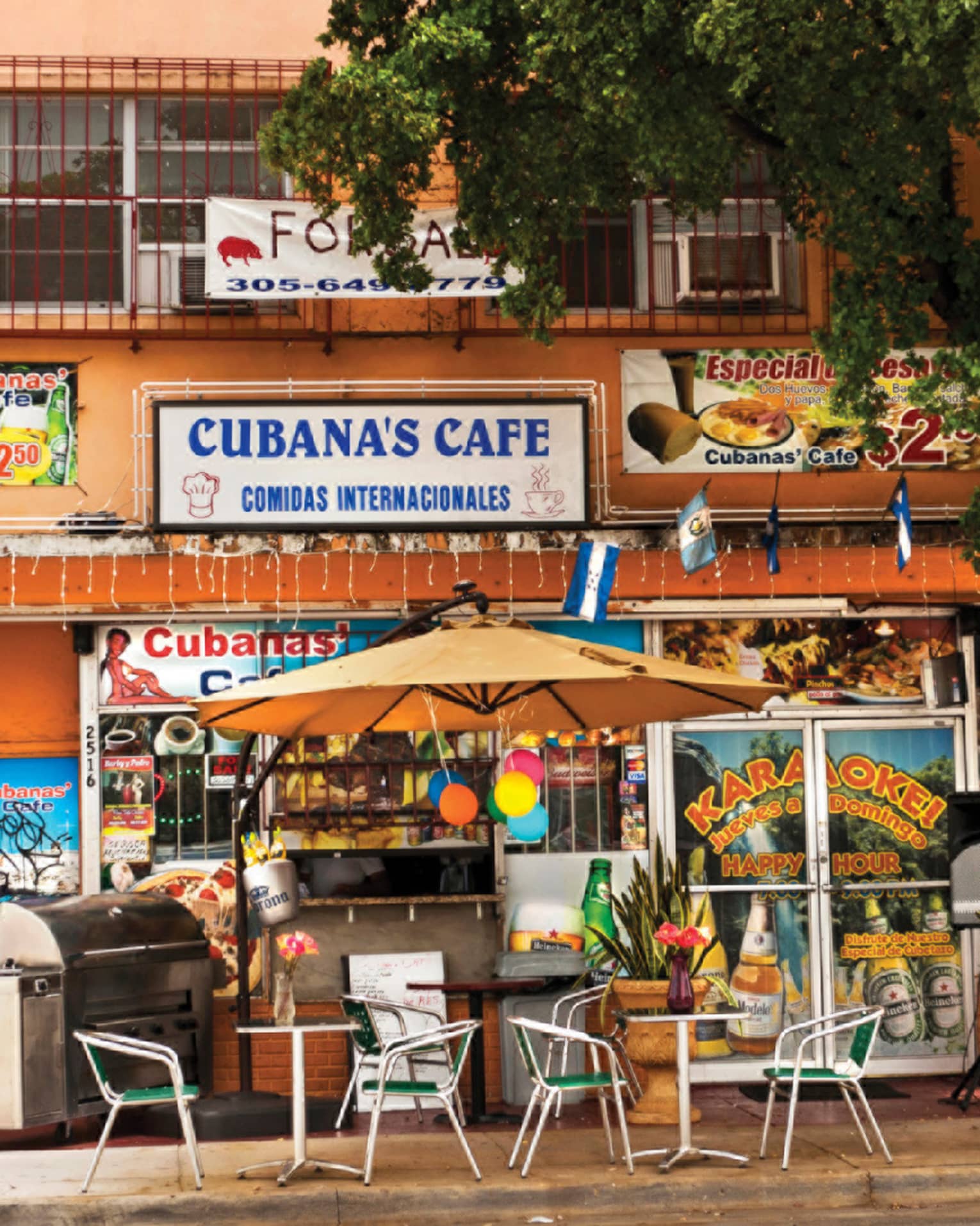 Exterior of colourful Cuban cafe with tables and chairs at Little Havana in the Calle Ocho