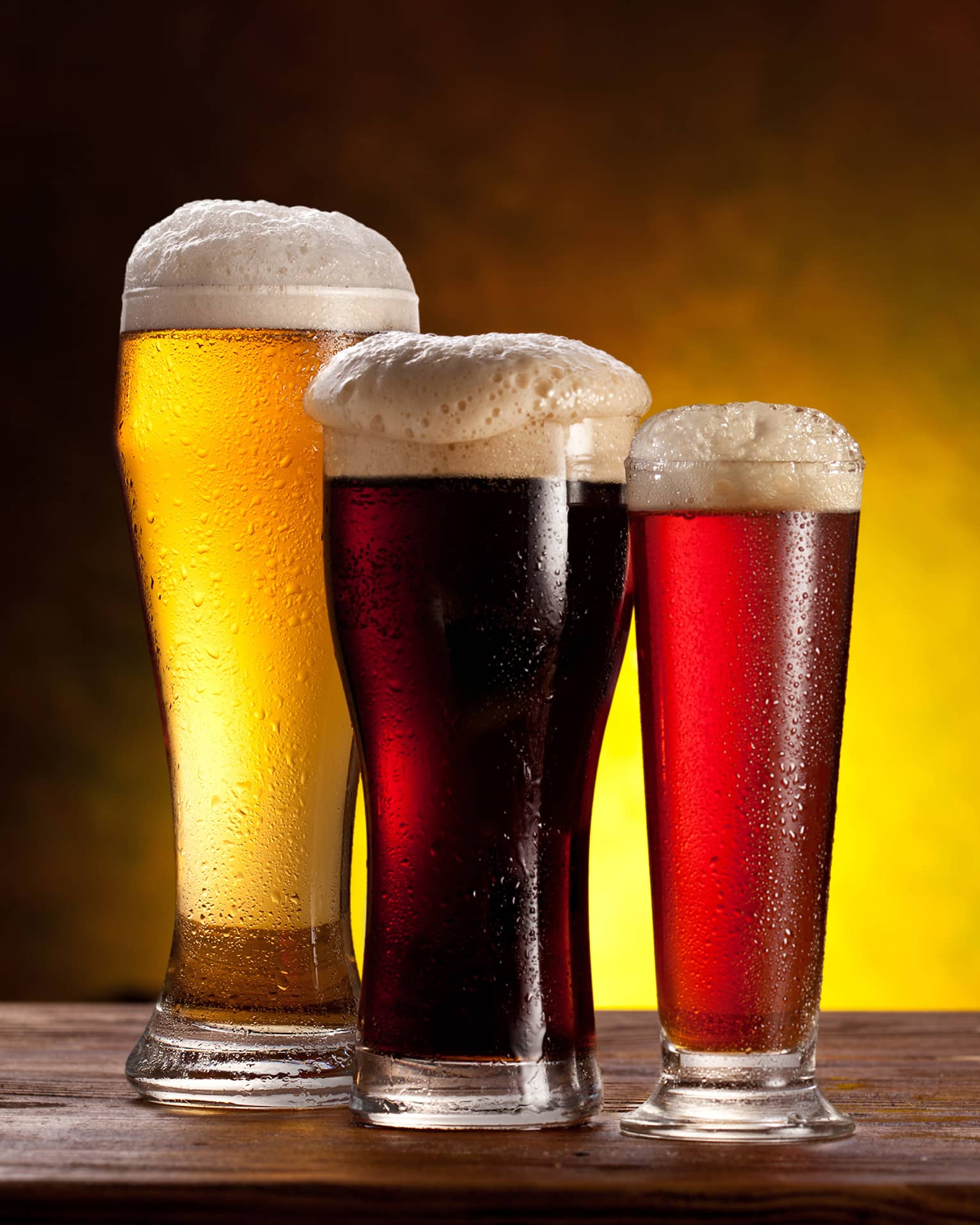 Three glasses of beer of varying colours.