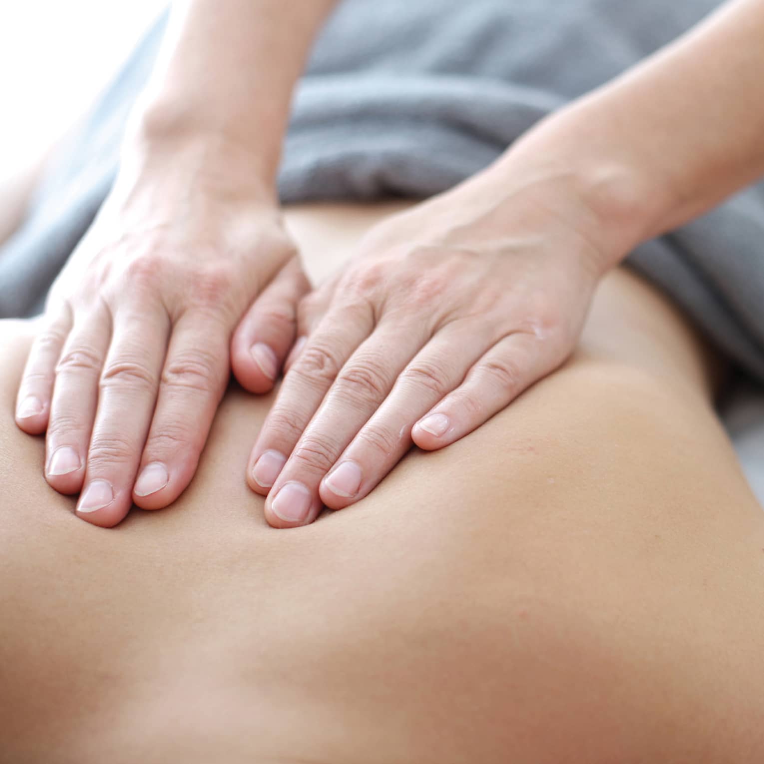 Hands massaging bare shoulders, back