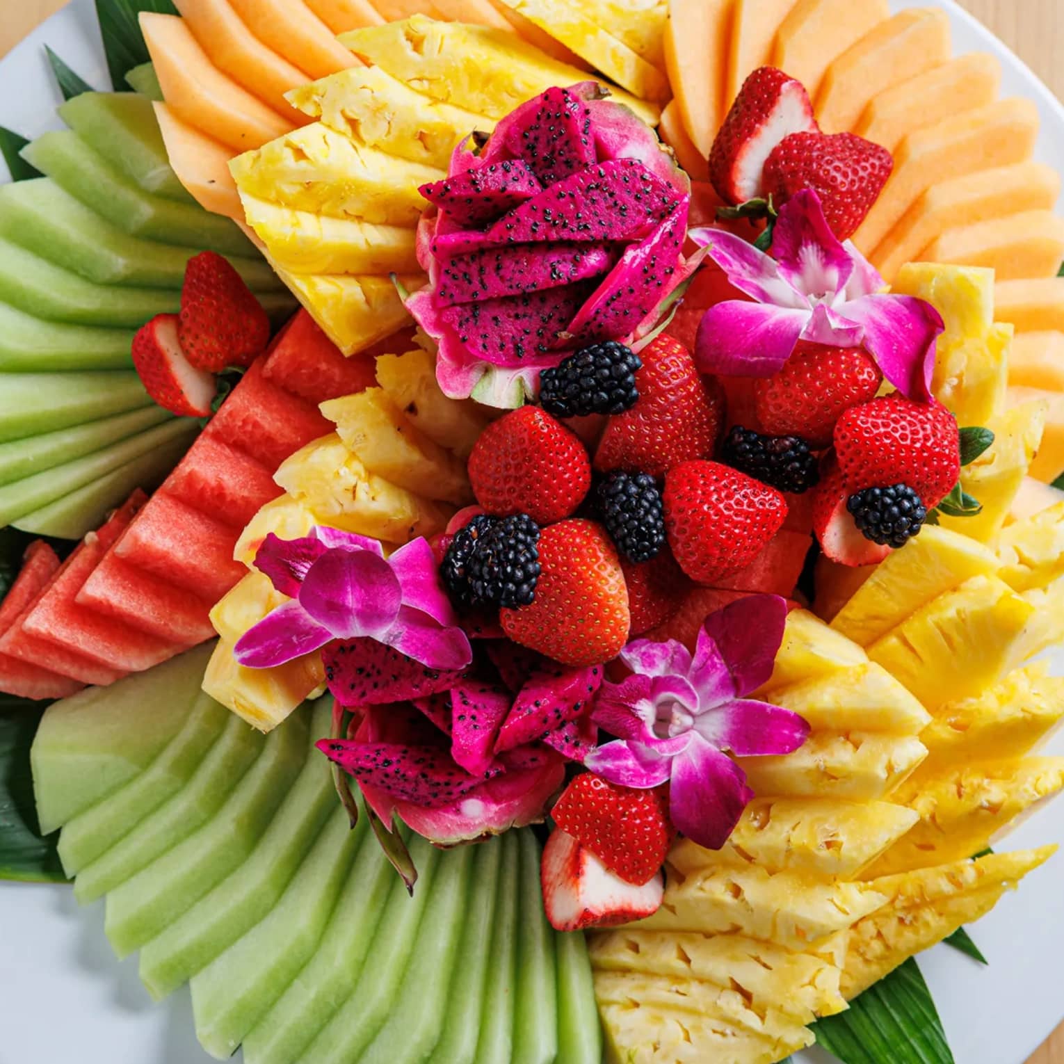Plate of many different vibrantly colourful fruits