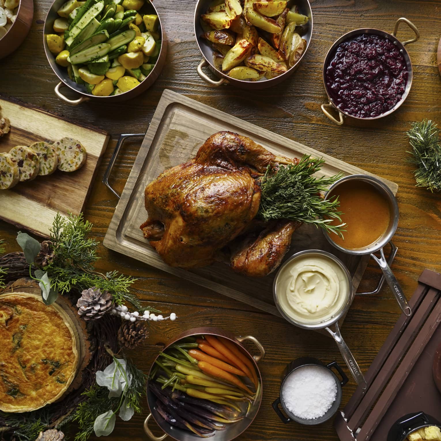 A full festive feast with a Turkey in the centre, and several copper pots of stewed vegetables surrounding