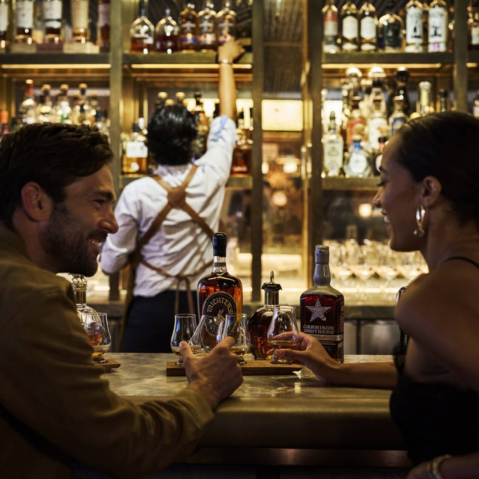 A couple enjoys cocktails at a modern bar