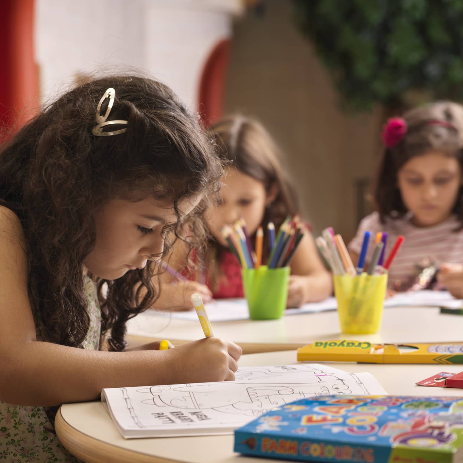 A group of young girls using markers on colouring books.