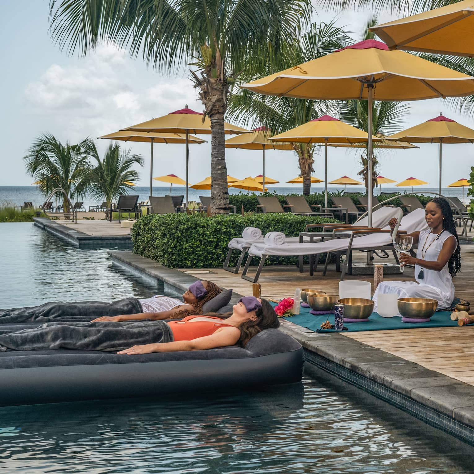 Two people laying on floats in the water during a meditation