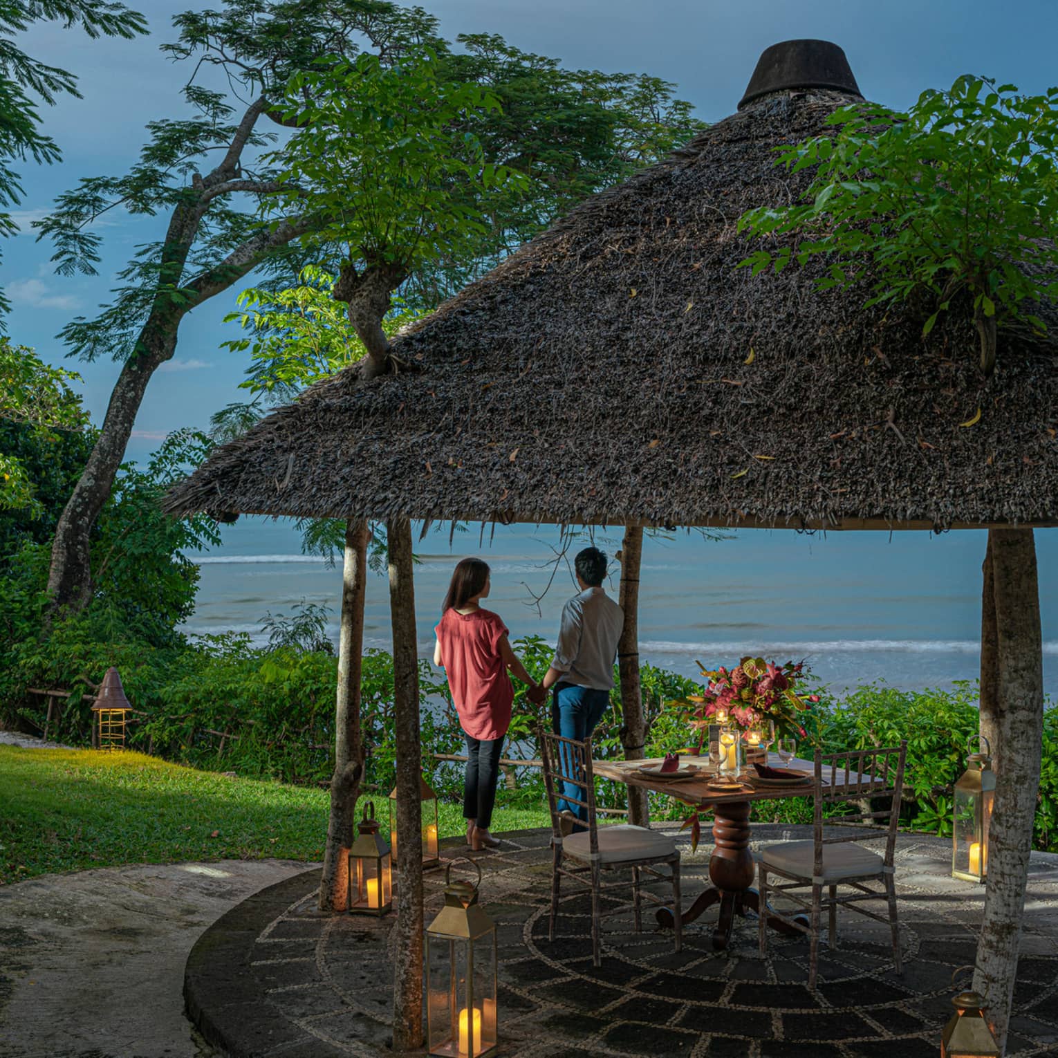 A couple enjoys a private outdoor dinner at dusk