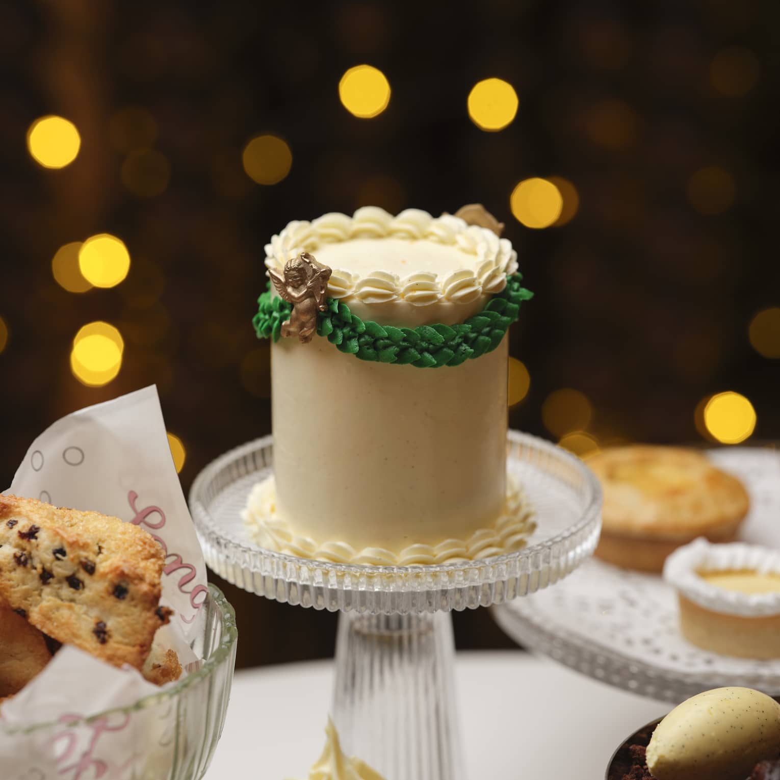 A cake stand and serving dishes bearing cakes and other baked goods