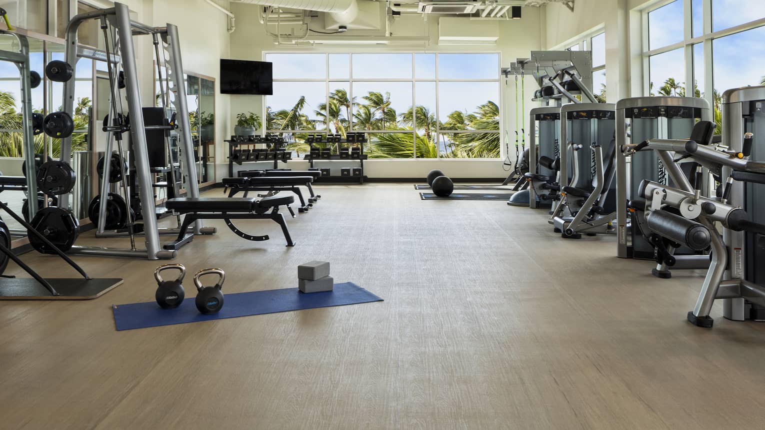 Large light-filled fitness centre with various weight training machines, free weights and cardio machines at Four Seasons Resort Oahu
