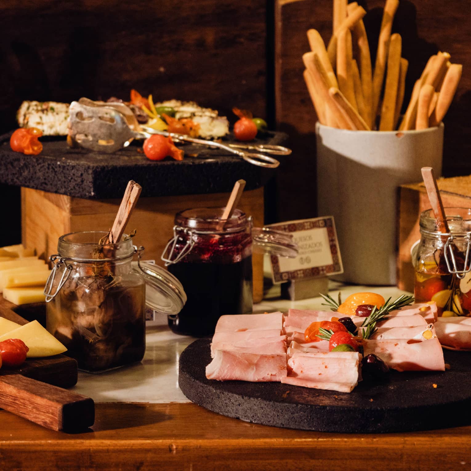 A display of sliced cheeses, meats and bread along with condiments