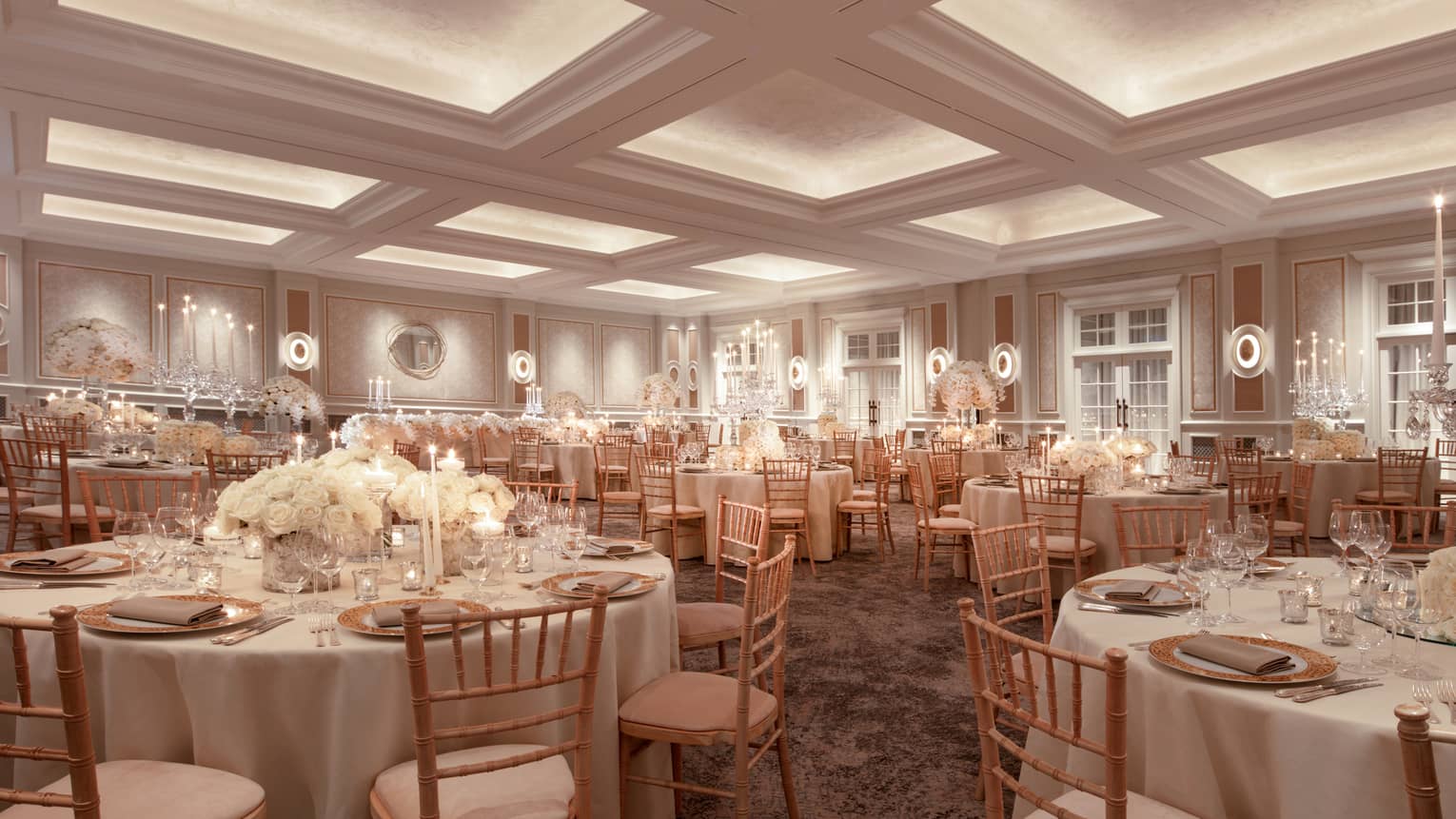 Wedding banquet tables with white linens, flowers in ballroom