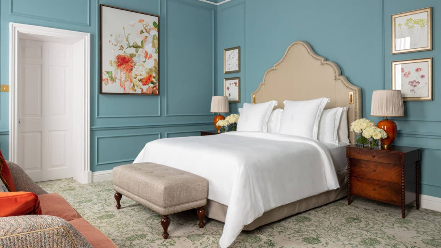 Guest room with Queen bed, white linens, paisley carpeting, cherry bed side table, turquoise walls
