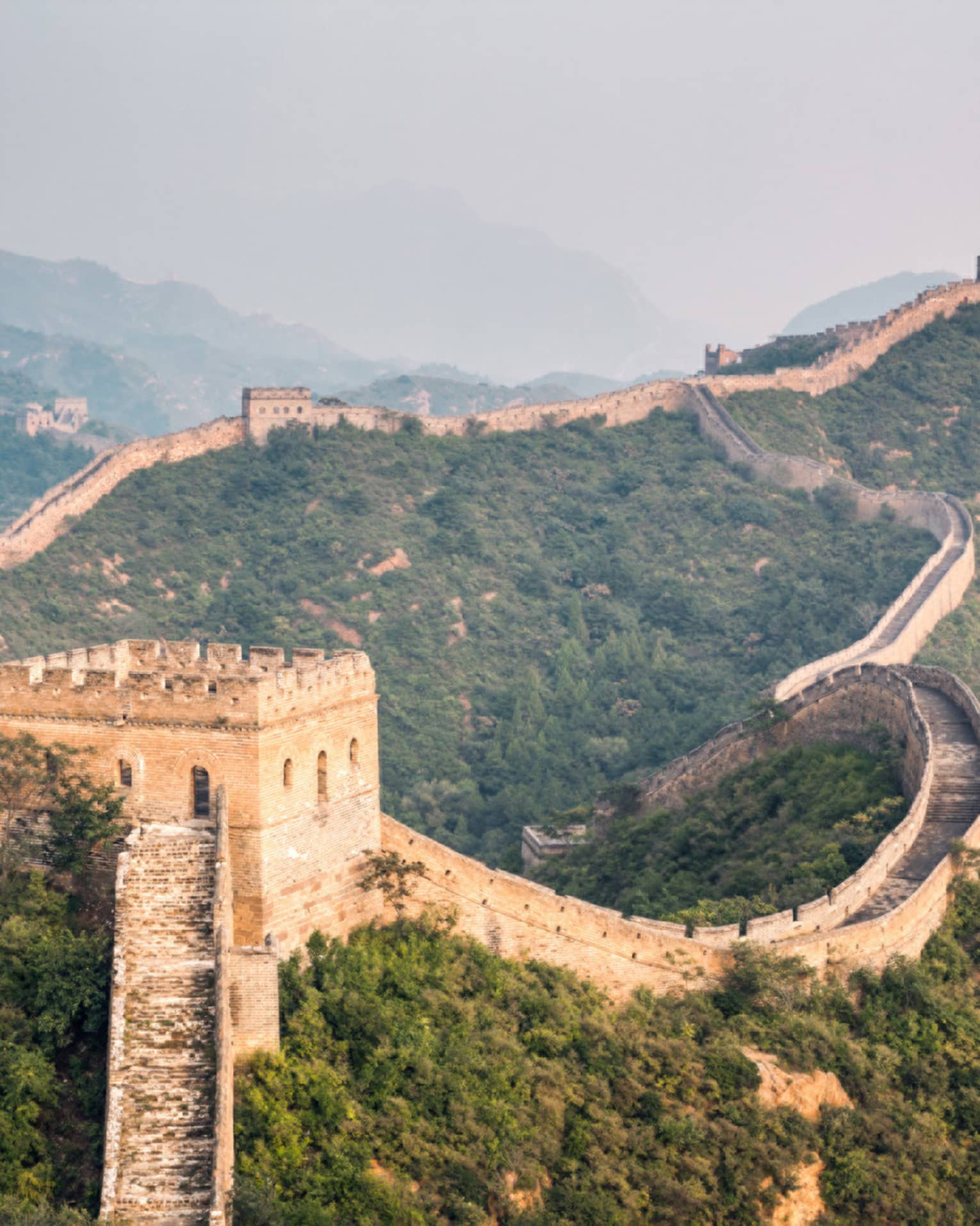 Great Wall of China winding along green mountain