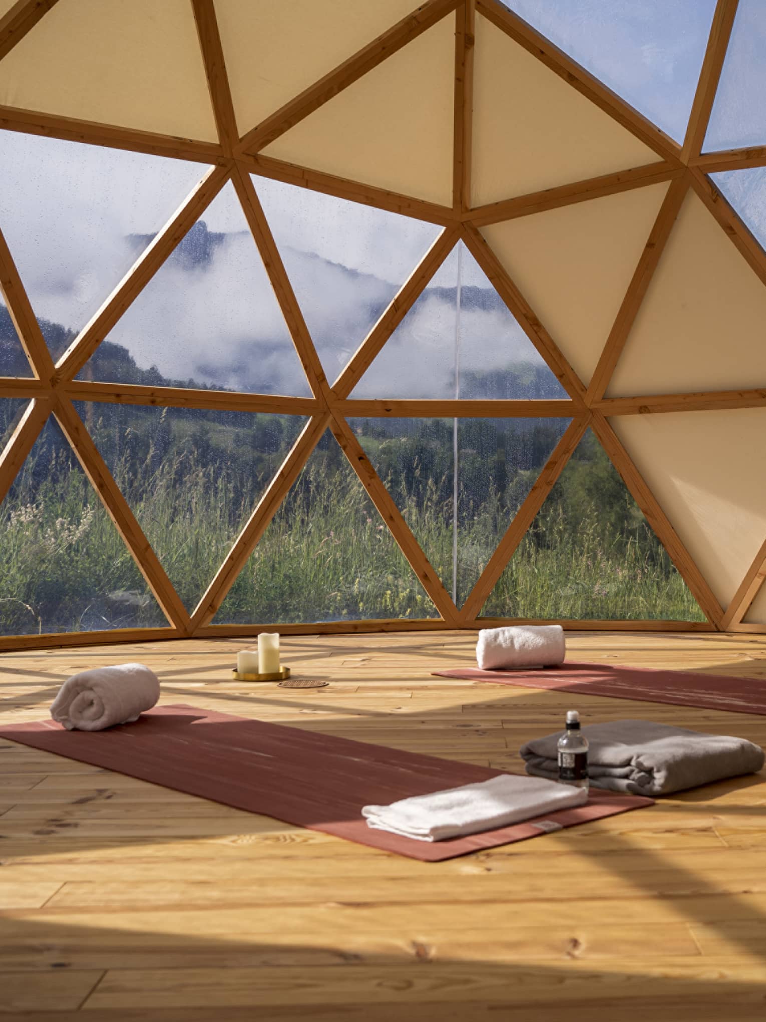 Spa studio set with two yoga mats and mountain view outside hive-like windows