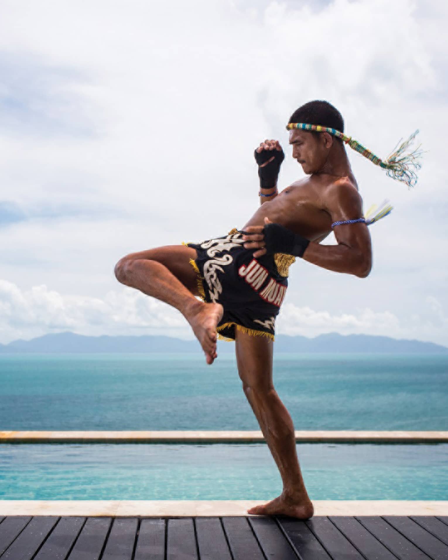 A guest practicing Muay Thai kickboxing by the ocean