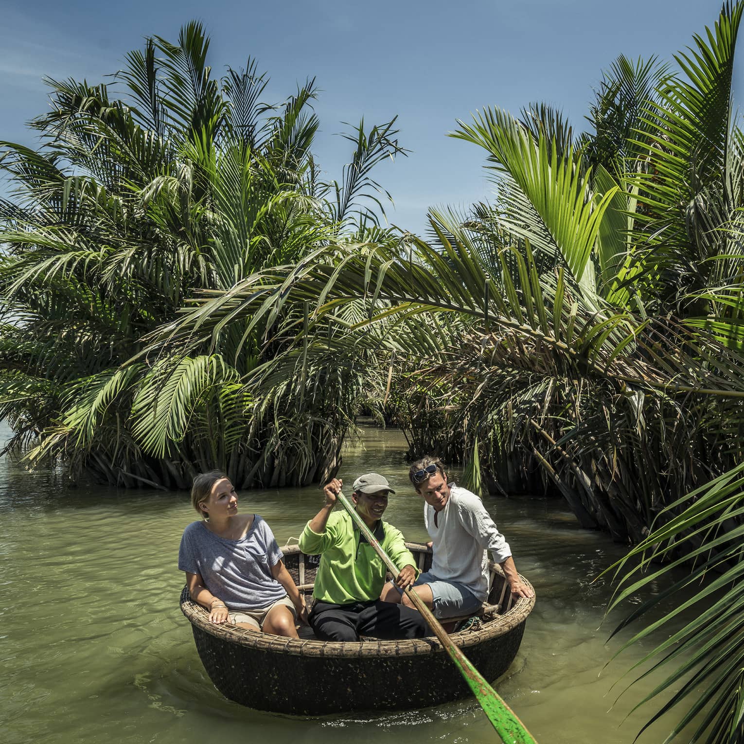 A couple and a guide in a Hoi An tour basket boat 