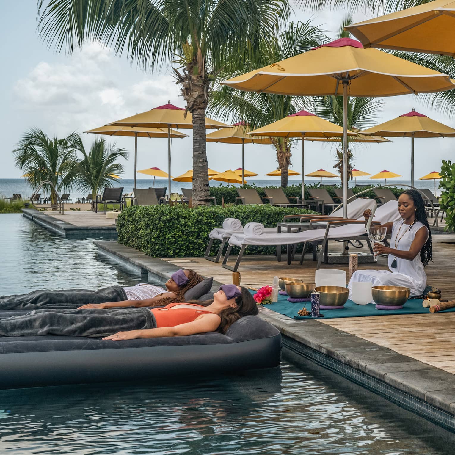 Two people laying on floats in the water during a meditation