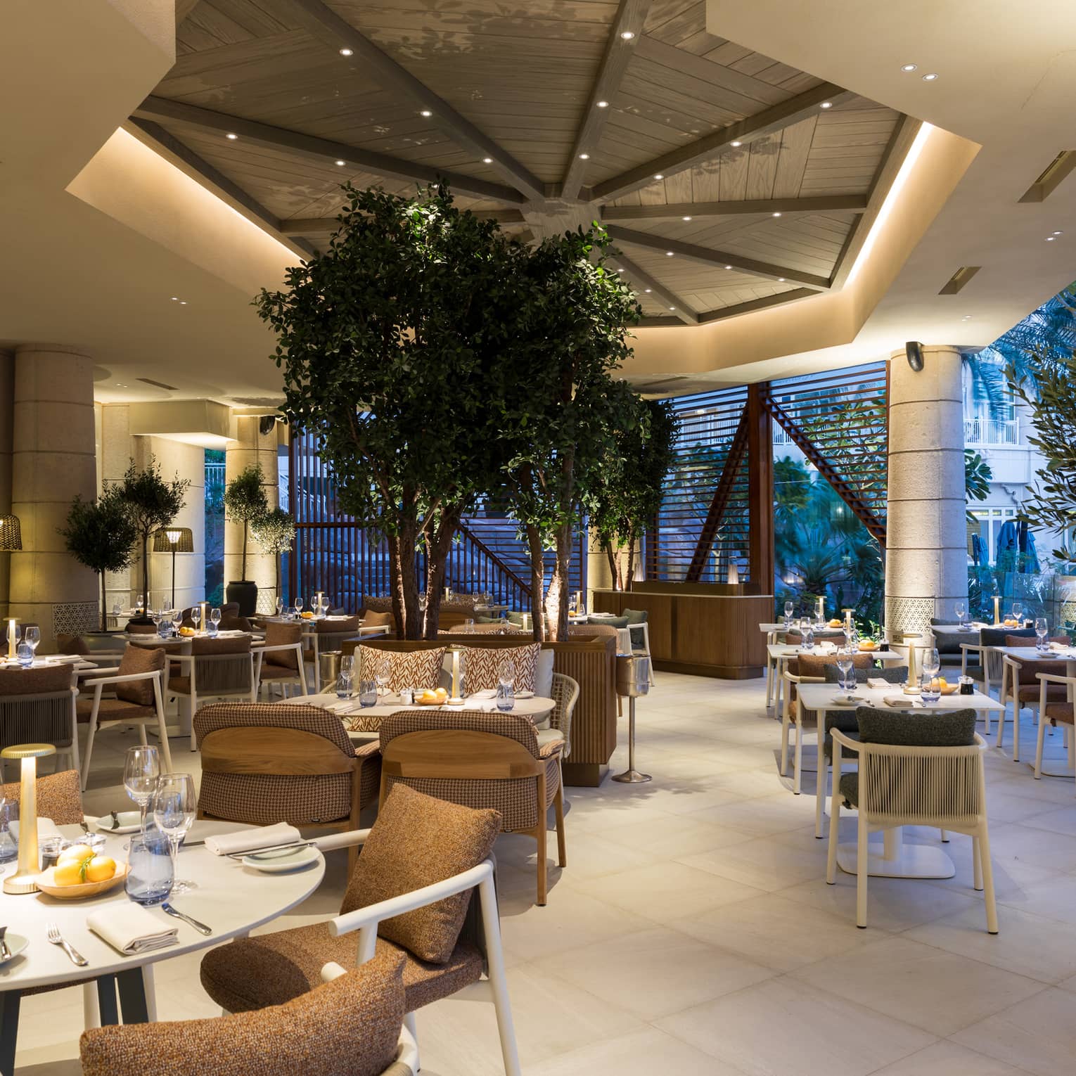 Restaurant terrace with white tile flooring, white tables and brown chairs