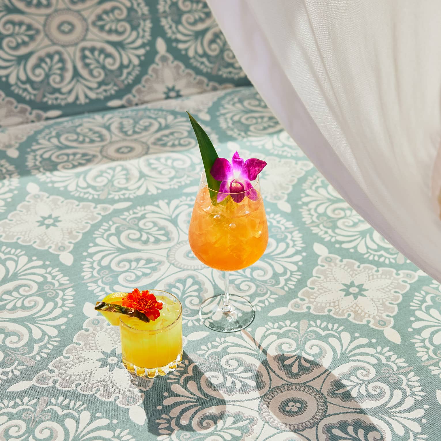 An orange and yellow cocktail on patterned tile.