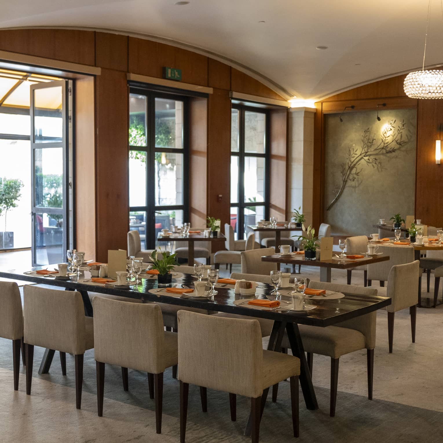 Restaurant dining room with tables next to a wall of windows