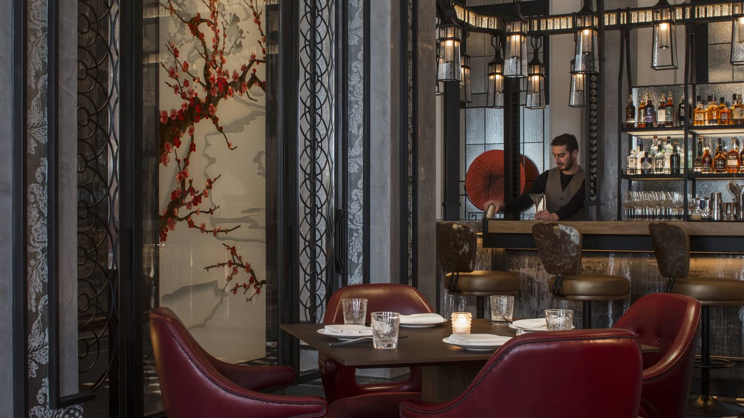 The onrnately decorated dining room at Mei Ume with a bartender preparing a cocktail at the bar