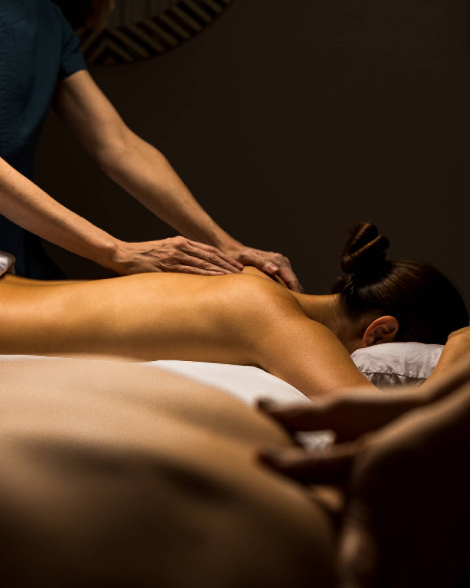 Two guests lay side by side for massage treatments
