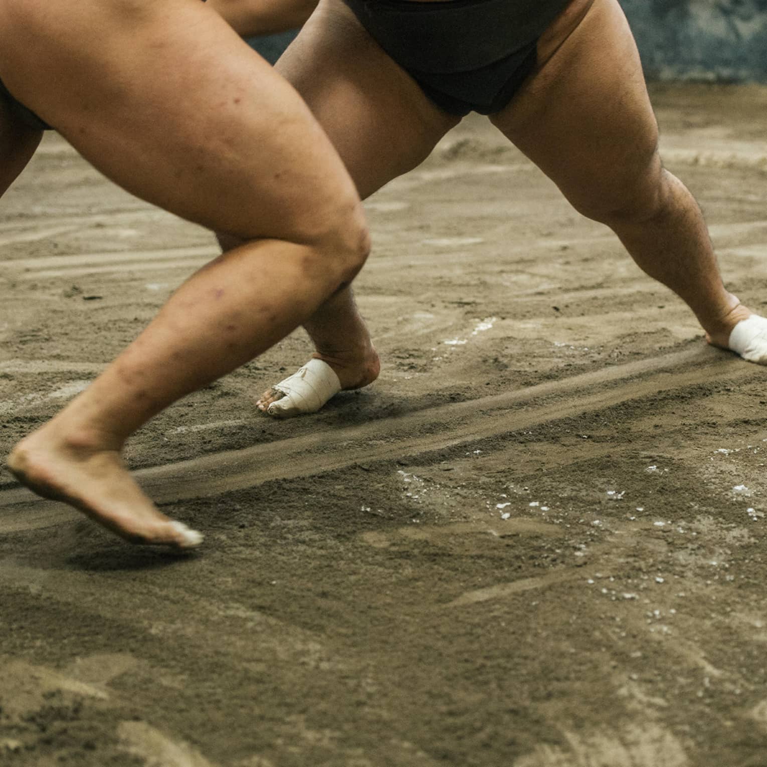 Two sumo wrestlers participate in a match