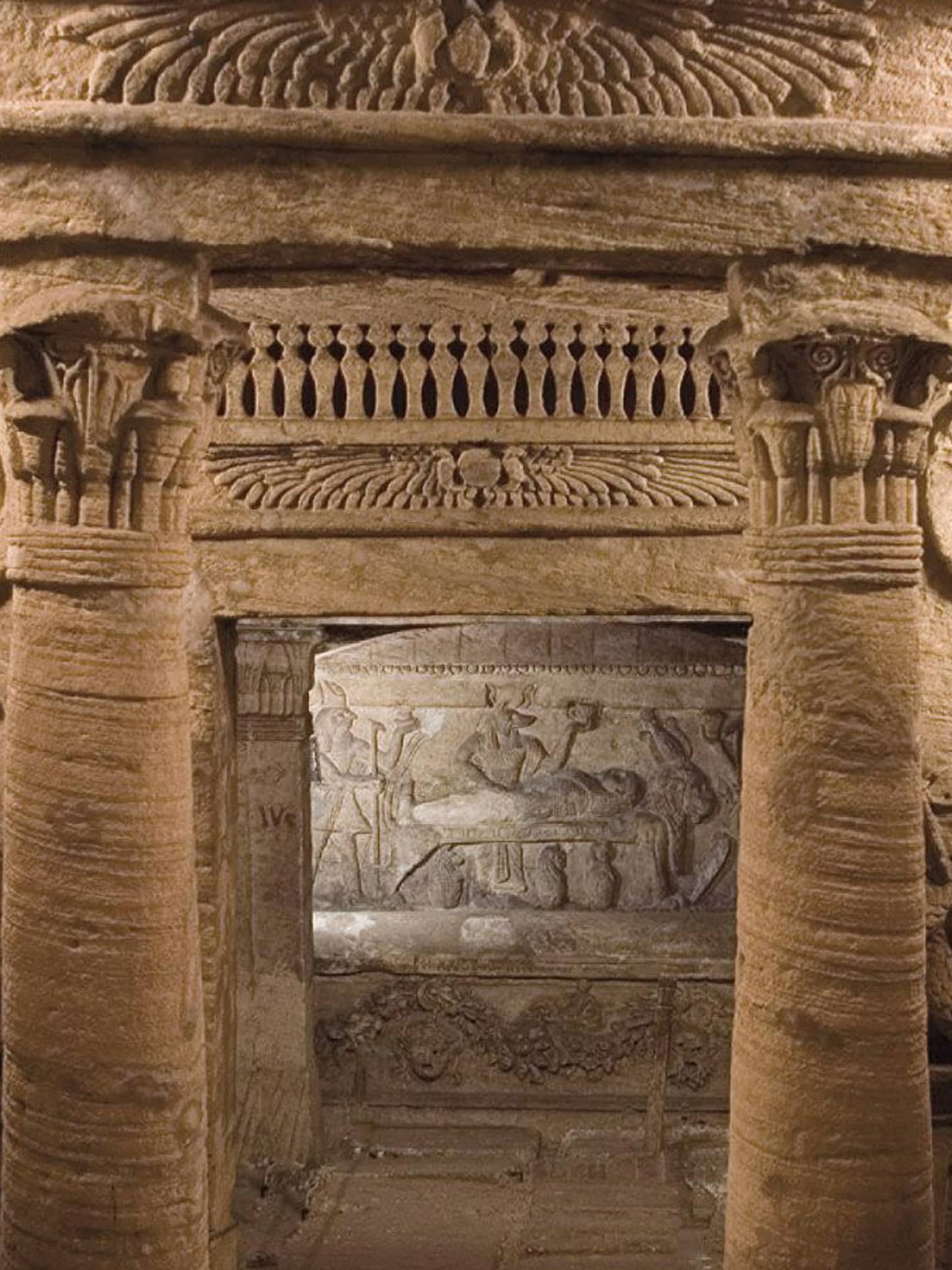 Historic Alexandria ruins with carved columns, snakes 