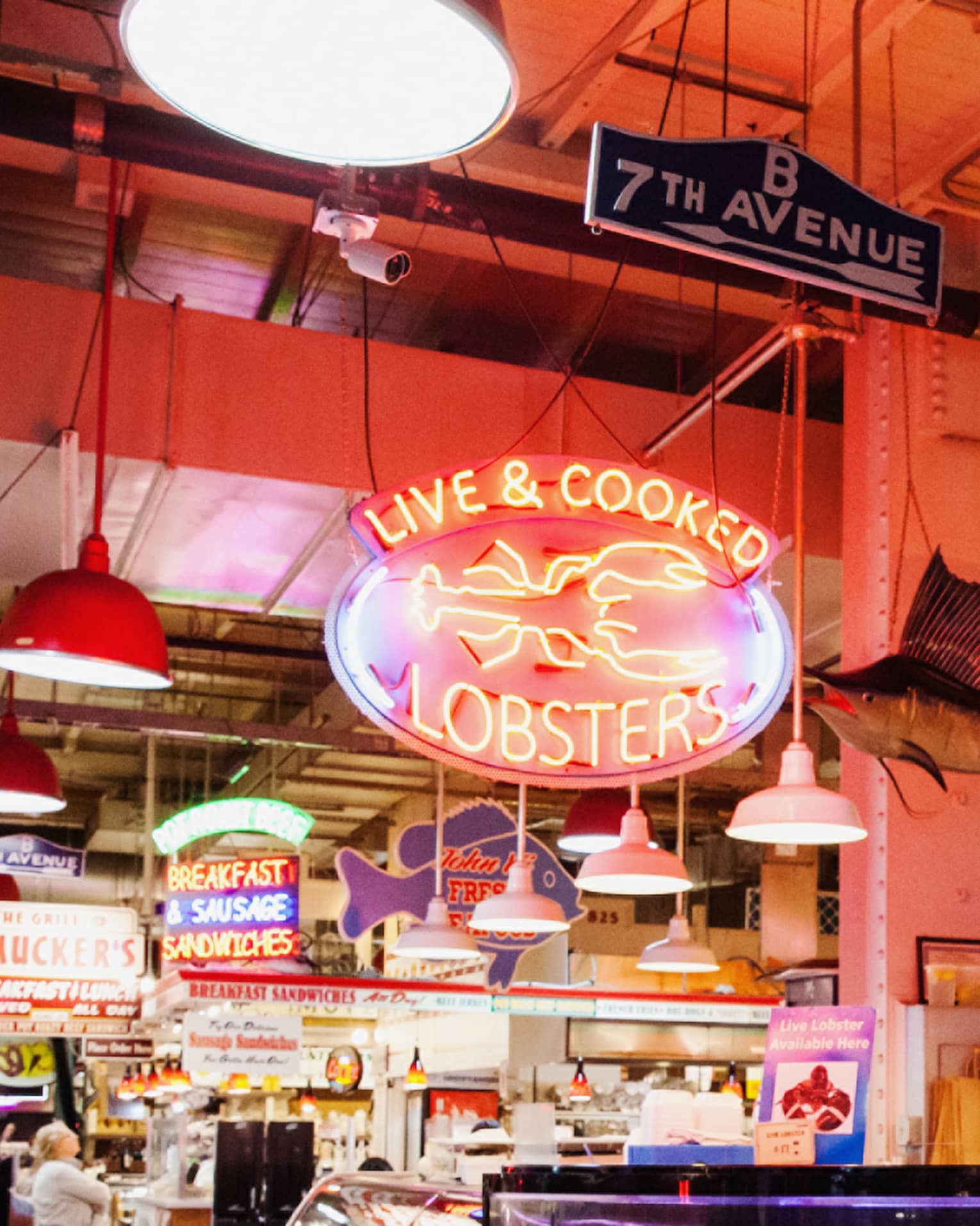 A large indoor market featuring fresh seafood behind glass windows.