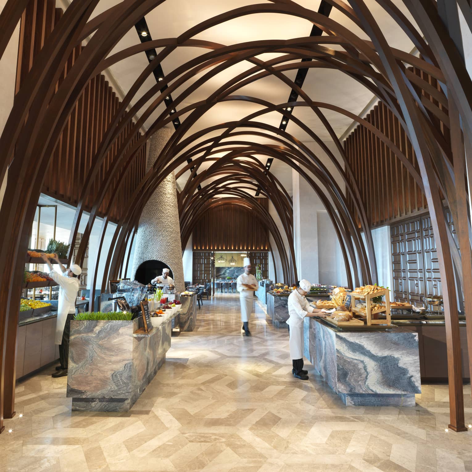 Soaring ceilings, wood arches over marble buffet tables where chefs prepare food