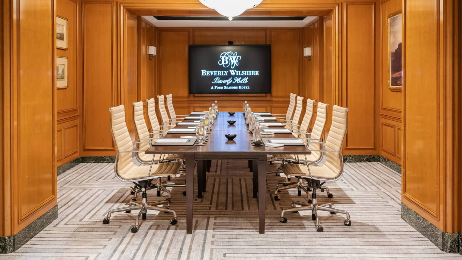 The entrance to a meeting room with a monitor at the end of the table